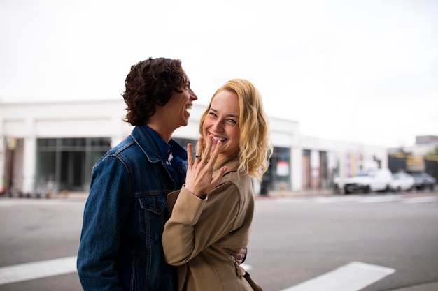 Couple outdoors in the city after proposal with engagement ring