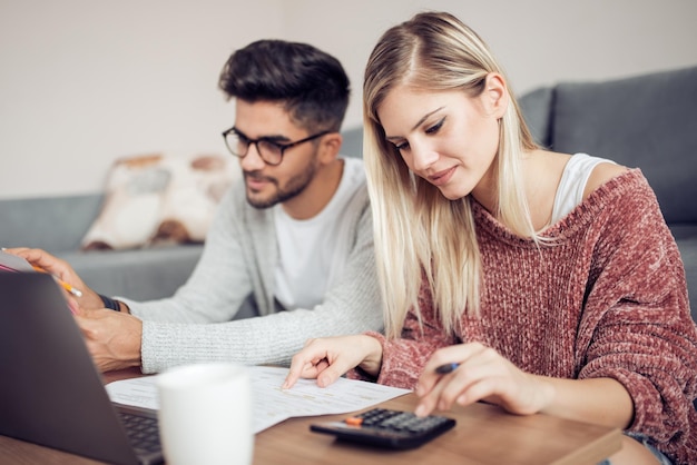 Couple paying their bills with laptop