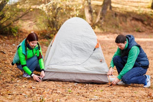 Couple pitching tent in countryside