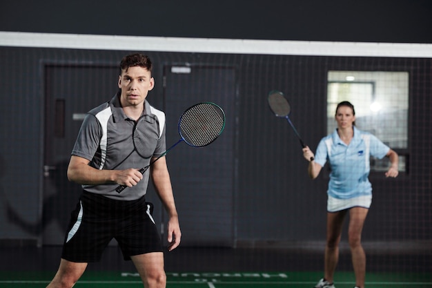 Couple Playing Badminton on Court