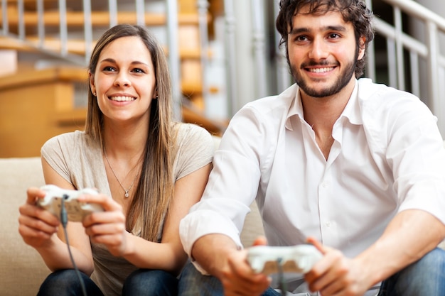 Couple playing video games at home