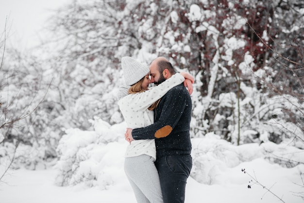 Couple playing with snow in the forest