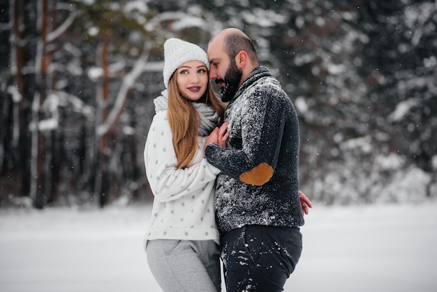 Couple playing with snow in the forest