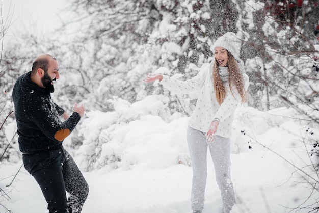 Couple playing with snow in the forest