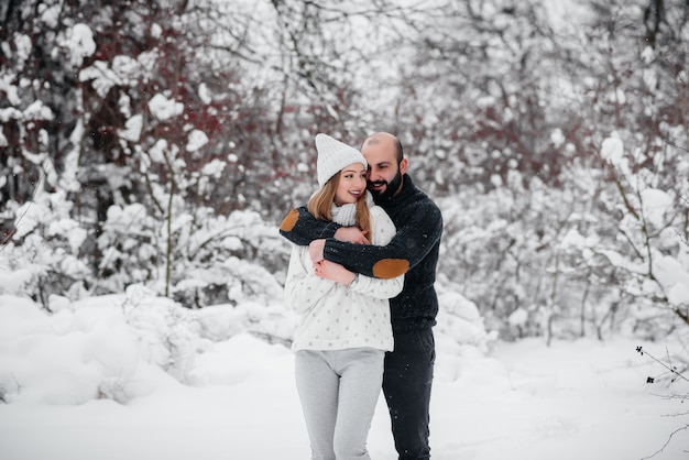 Couple playing with snow in the forest