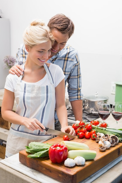 Photo couple preparing food together in the kitchen