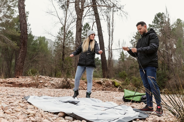 Couple preparing tent for camping