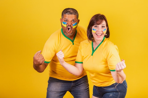 Couple redhaired woman and black man Brazilian soccer fans celebrating