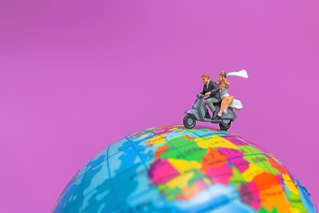 Photo couple riding the motorcycle on the globe valentines concept