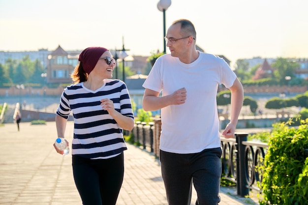 Couple running in city, mature man and woman together, active sport fitness healthy lifestyle of middle-aged people