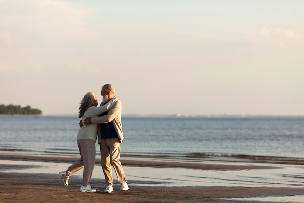 Couple at seaside hugging full shot