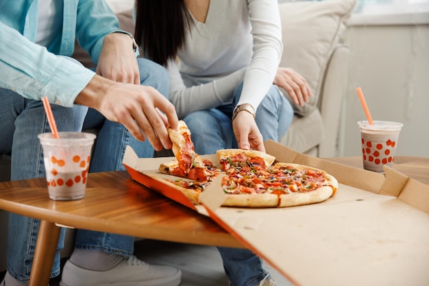 Couple sharing pizza and eating