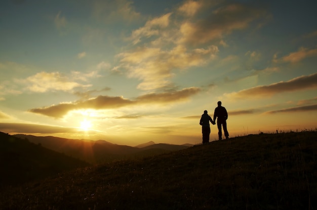 Couple silhouette on the sunset background