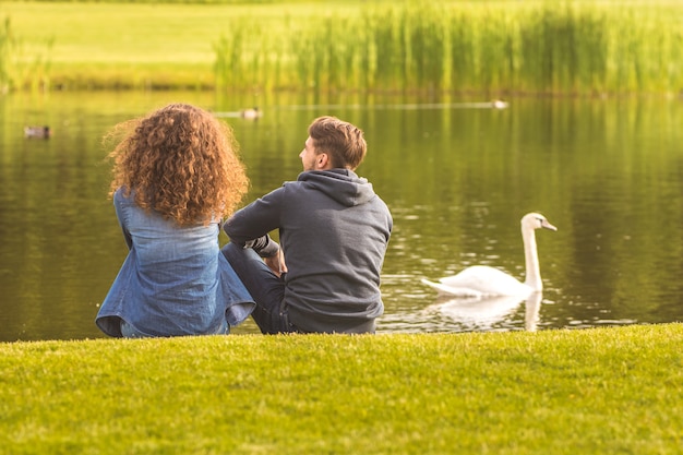 The couple sit on the river shore