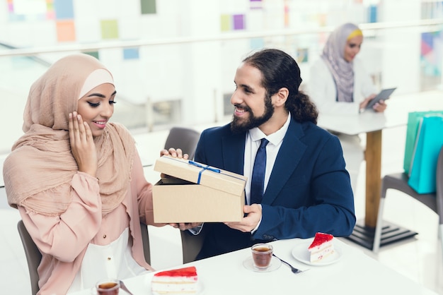 Couple Sitting in Cafe after Shopping. Woman in Hijab.