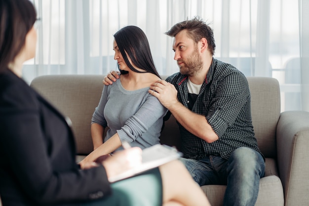 Couple sitting on sofa, psychologist reception