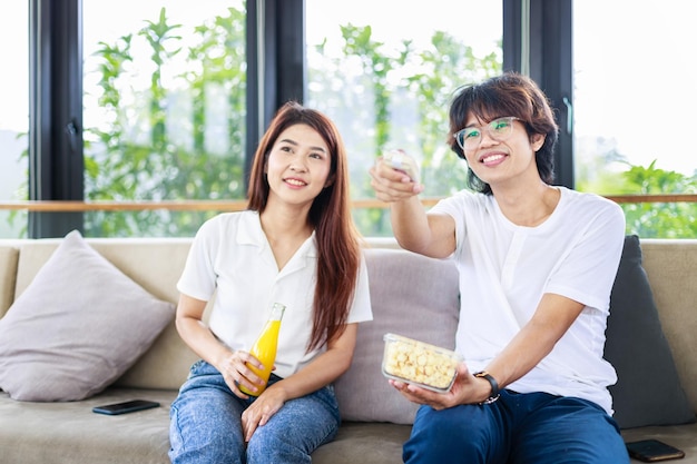 A couple sitting and watching movie together in living room happiness and married people concept