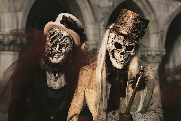 Couple in skeleton costumes at carnival in Venice. Halloween celebration