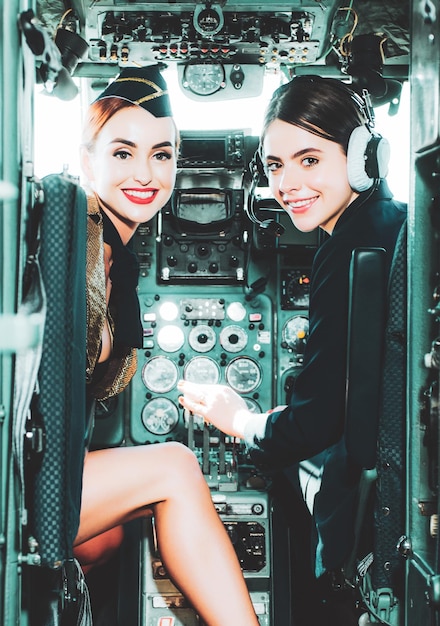 Couple smiling female pilots in the aircraft portrait of smiling female pilots looking at camera in