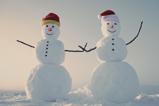 Couple snowman in winter outdoor new year snowmen from snow in santa hat