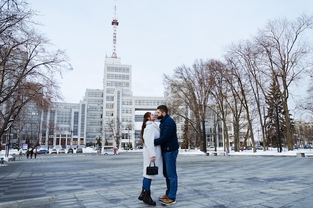 couple in snowy park. young man, woman. warm sweaters. People walking. Family winter holidays. Date