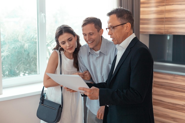 Couple speaking with realtor while choosing the house