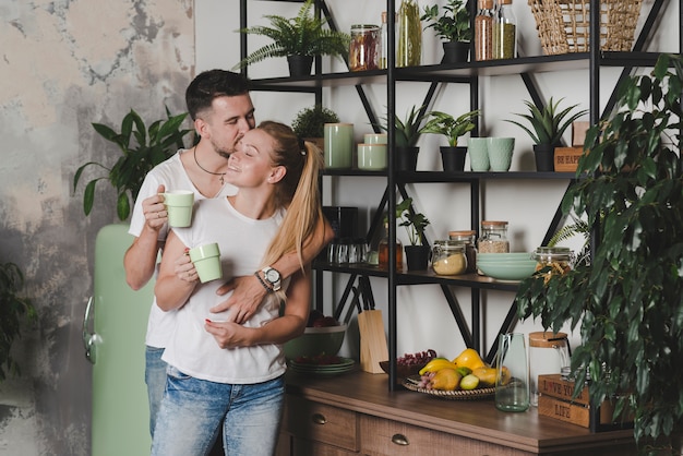 Couple standing in kitchen loving each other