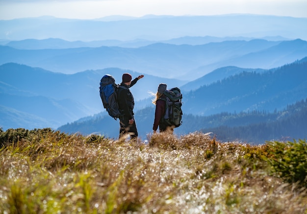 The couple standing on the mountain with a beautiful view