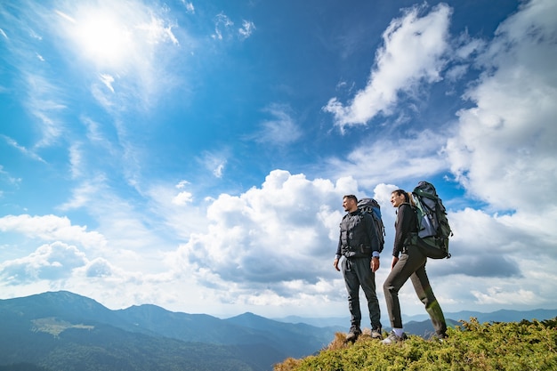 The couple standing on the mountain with a picturesque cloudscape