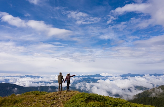 The couple standing on the picturesque mountain