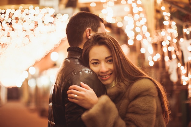 Photo couple at the street before christmas time. bokeh lights decorations backdrop