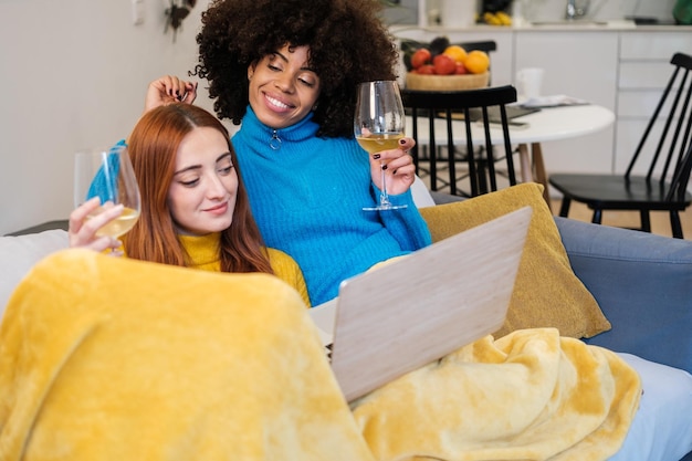 Couple taking a break watching a movie together while having a glass of wine pride and break concept