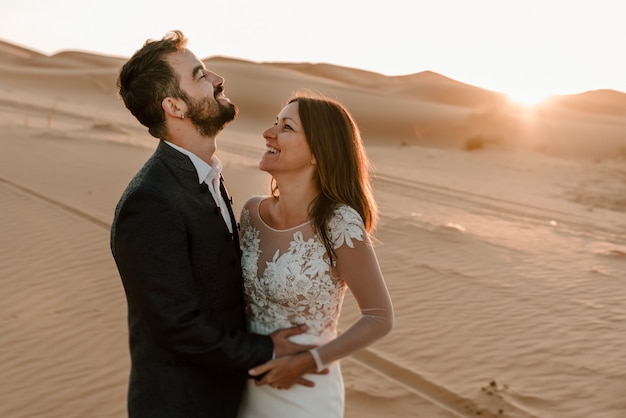 A couple in their wedding dresses in the desert