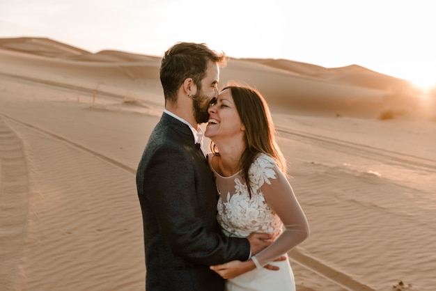 A couple in their wedding dresses in the desert