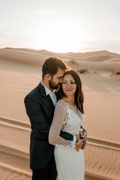 A couple in their wedding dresses in the desert