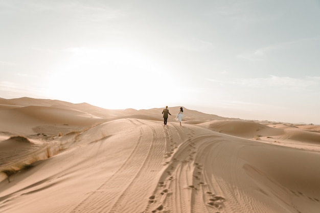 A couple in their wedding dresses in the desert