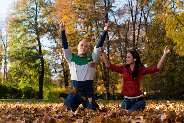 Couple Throwing Leaves In The Air