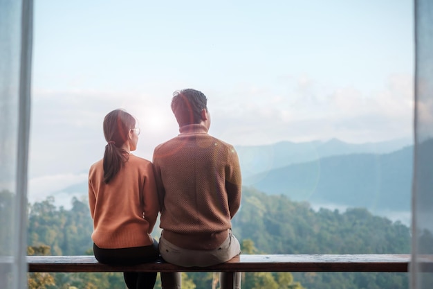 Couple tourist relaxing and looking mountain view at countryside home or homestay in the morning Vacation together travel honeymoon blogger journey trip and relaxing concept