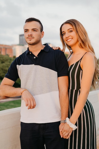 A couple of tourists are having fun with modern urban space in the background