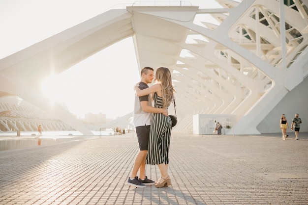 Couple of tourists is dancing in the modern urban space on a date at the sunset