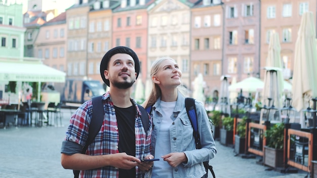 Couple of tourists using smartphone and admiring beautiful surroundings