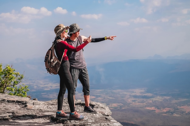 couple traveler are on top of the mountain and taking photo view of nature on holiday.