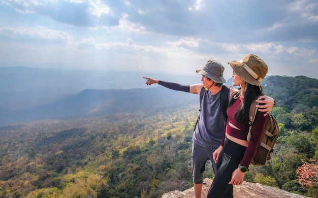 couple traveler are on top of the mountain and taking photo view of nature on holiday.