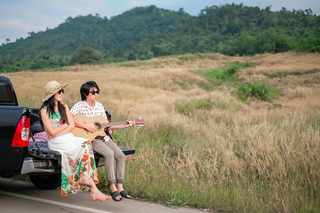 couple traveler have a relax time during traveling beside the road