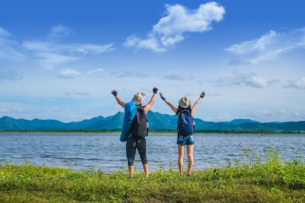 couple traveler standing near the lake  in the mountain