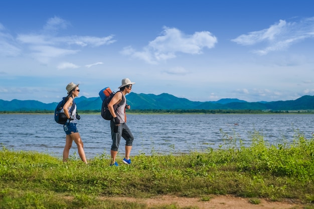 couple traveler walking near the lake  in the mountain