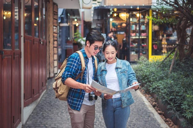 Couple Of Travelers Using Map For Sightseeing In Town