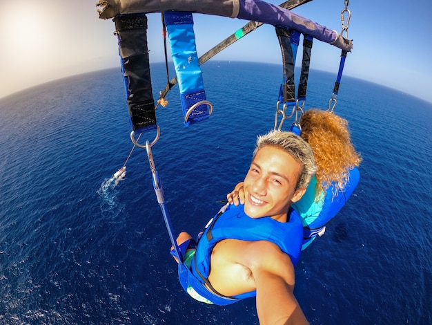 Couple of two happy people enjoying summer and vacations doing extreme activity on the sea