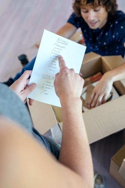 Photo couple unpacking moving boxes in their new house