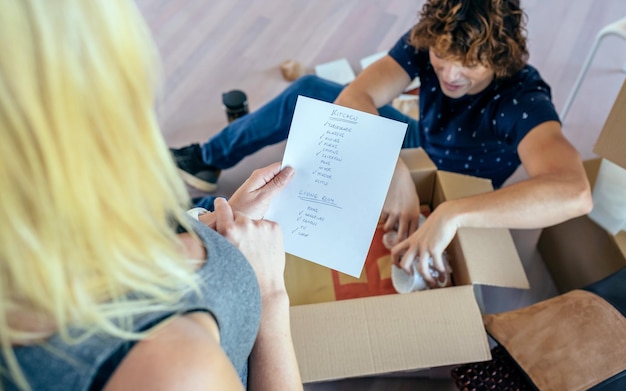 Photo couple unpacking moving boxes in their new house